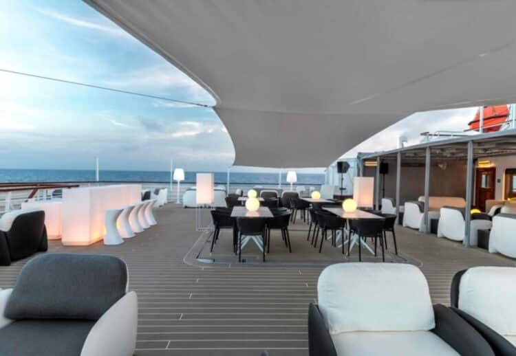 Pont extérieur aménagé d’un navire d’expédition en Antarctique avec tables et vue sur la mer.
