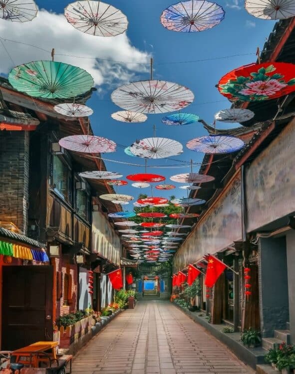 Ruelle décorée d’ombrelles colorées suspendues dans une ville du Yunnan