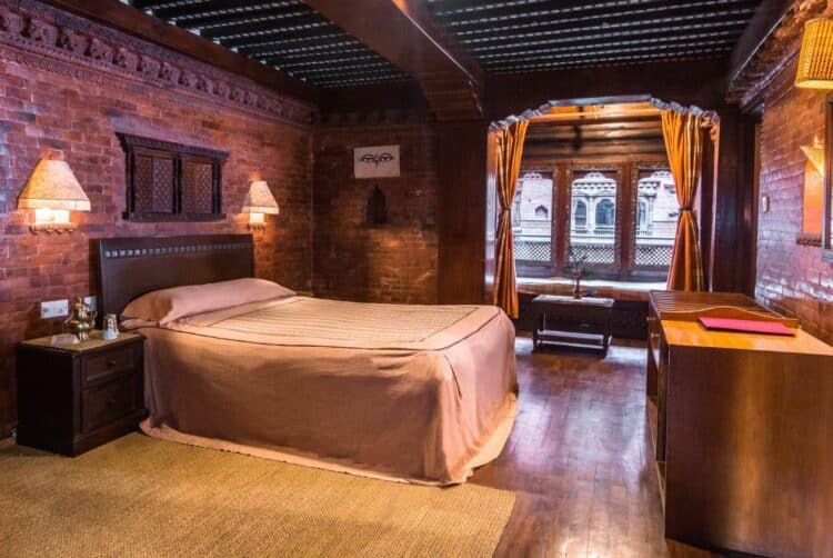 Chambre traditionnelle au Katipur Temple House à Katmandou avec mobilier en bois et murs en briques