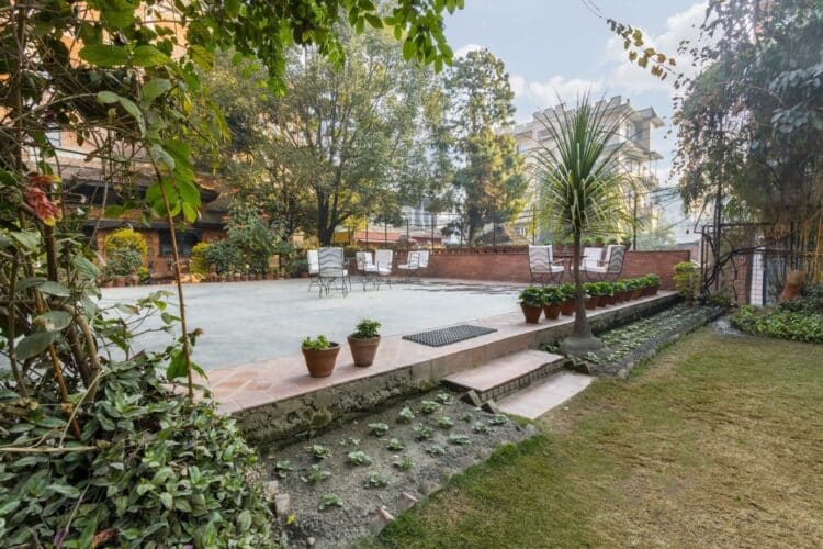 Jardin et terrasse extérieure du Katipur Temple House à Katmandou avec végétation et espace détente