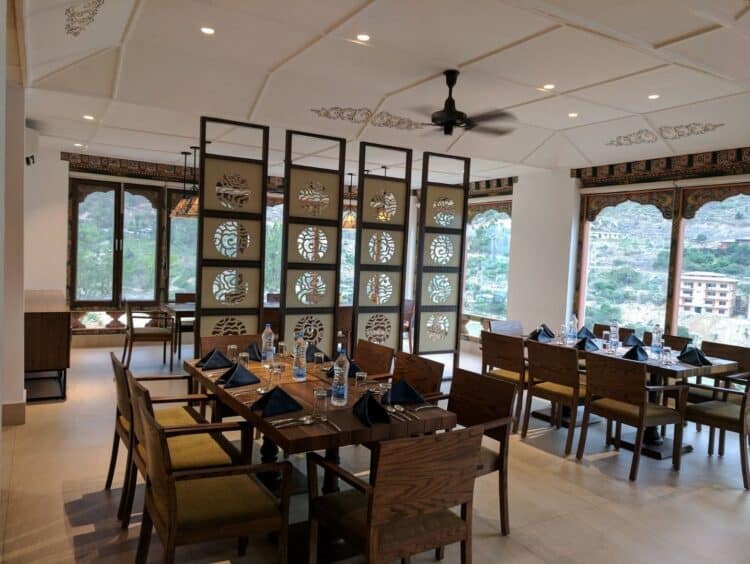 Salle de restaurant du Khuru Resort avec grandes fenêtres et vue sur la vallée