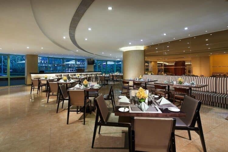 Salle de restaurant moderne et élégante dans un hôtel avec tables dressées et grandes baies vitrées