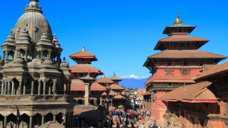 Temples traditionnels de style newar sur Durbar Square à Katmandou avec les montagnes de l’Himalaya en arrière-plan.