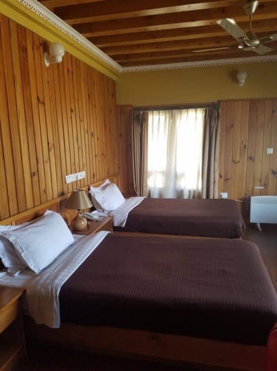Chambre spacieuse du Mandala Hotel au Bhoutan avec lit double, parquet et décoration élégante