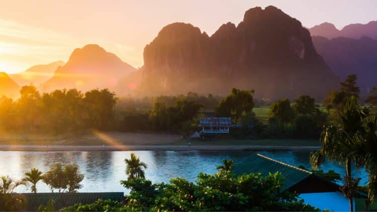 Paysage du Laos avec rivière, montagnes karstiques et lumière de coucher de soleil
