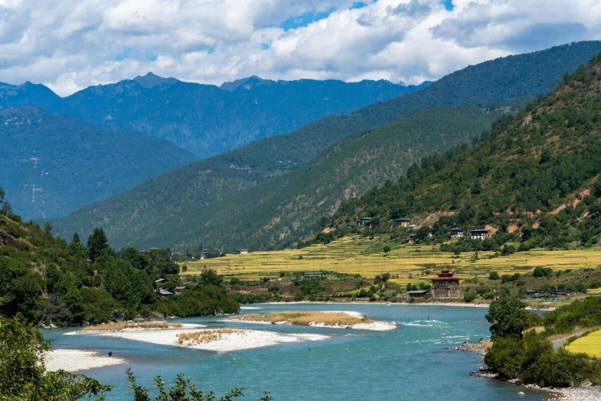 Vallée de Punakha au Bhoutan avec rivière sinueuse, rizières en terrasses et montagnes boisées