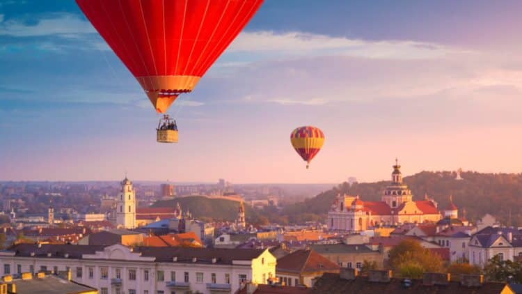 Montgolfières survolant la ville historique de Vilnius au coucher du soleil