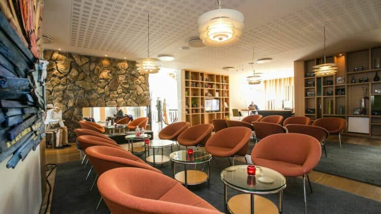 salon d hotel en islande avec fauteuils confortables et cheminee en pierre