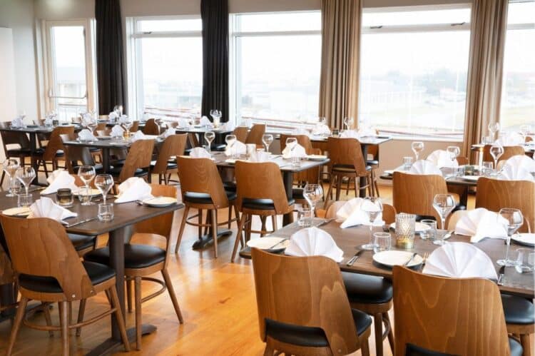 salle de restaurant en islande avec tables dressees et grandes baies vitrees