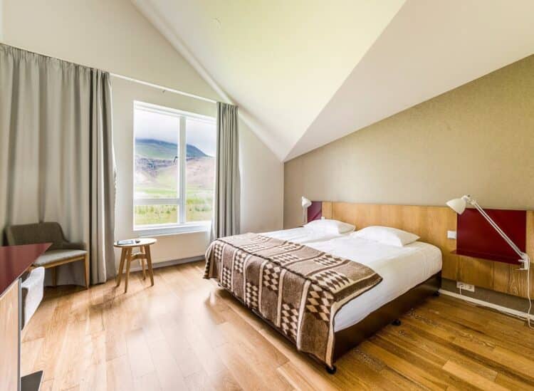 chambre d hotel en islande avec lit double et vue sur montagnes par la fenetre