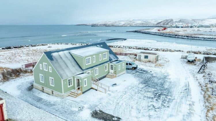 maison verte en islande pres de la mer avec paysage enneige et littoral