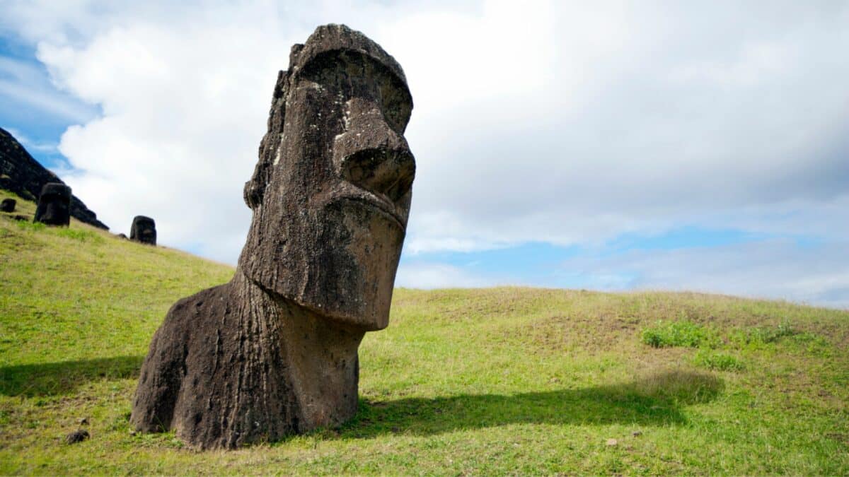 statue moai sur l ile de paques sur une colline verdoyante sous un ciel nuageux
