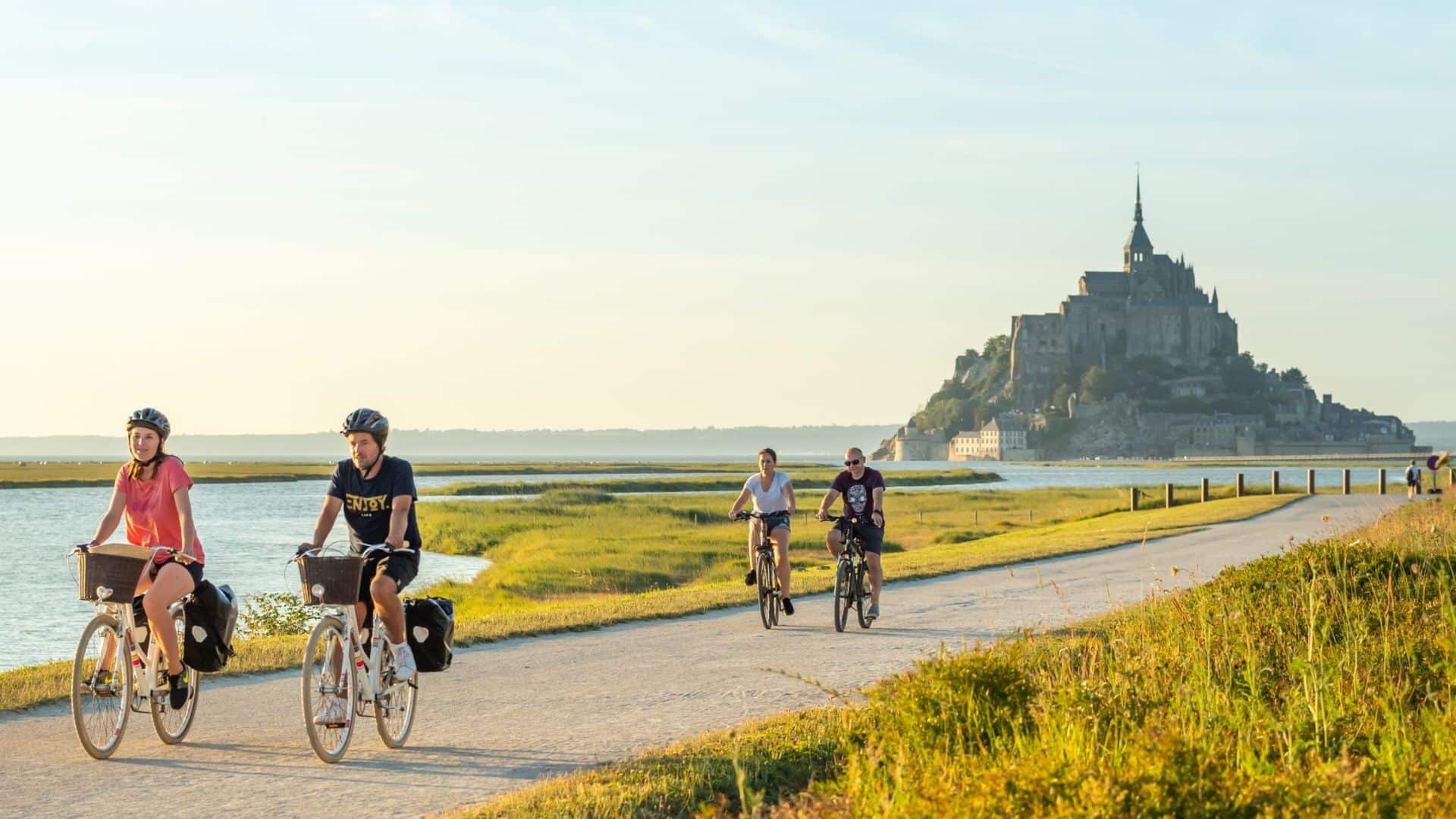 cyclistes sur piste cyclable face mont saint michel paysage naturel