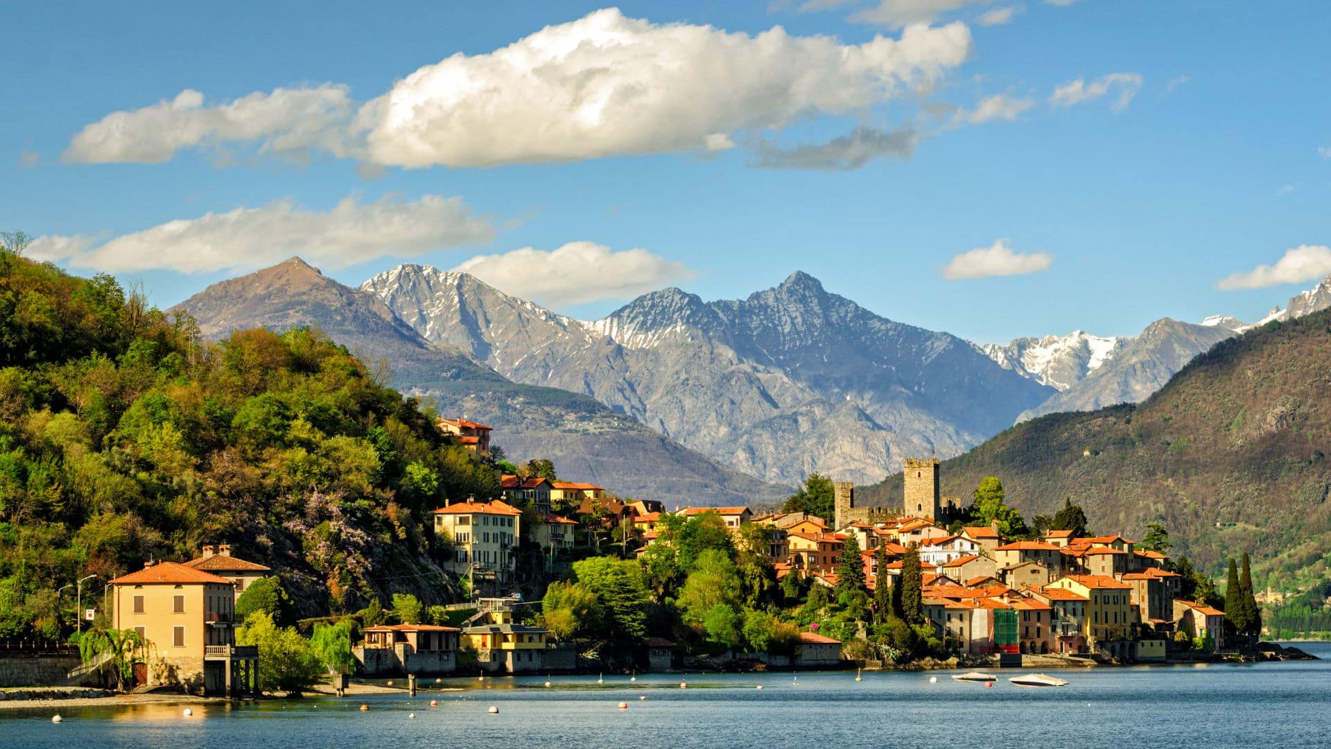 Village coloré au bord du lac de Côme avec montagnes en arrière-plan en Italie