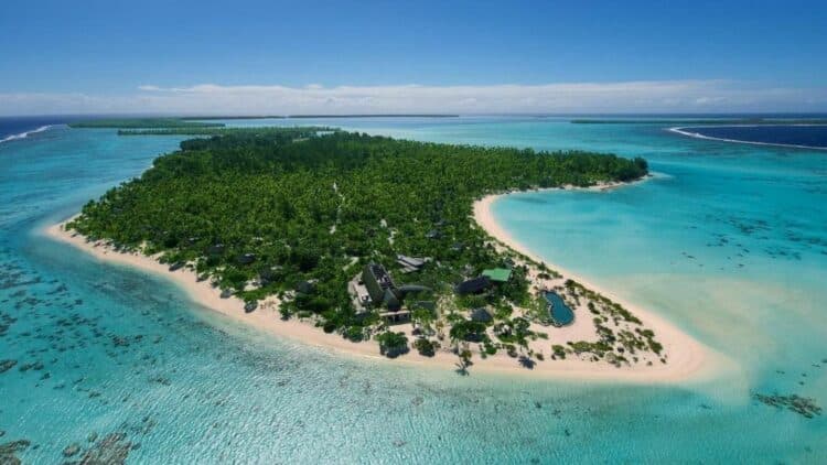 île tropicale entourée d’un lagon turquoise vue depuis le ciel en Polynésie française