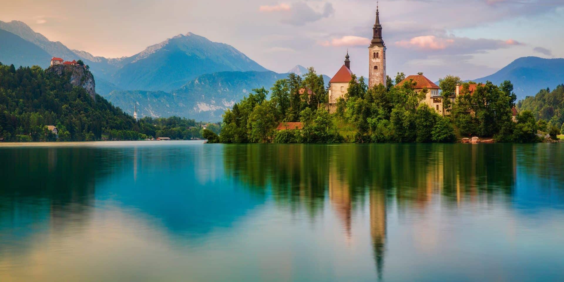 Île avec église au centre du lac de Bled entouré de montagnes en Slovénie