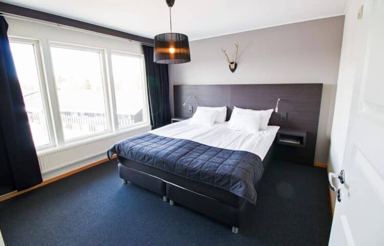 Chambre d’hôtel moderne avec lit double et grande fenêtre en Suède