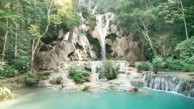 Cascade à plusieurs niveaux dans une forêt tropicale dense au Laos avec eau claire et végétation luxuriante