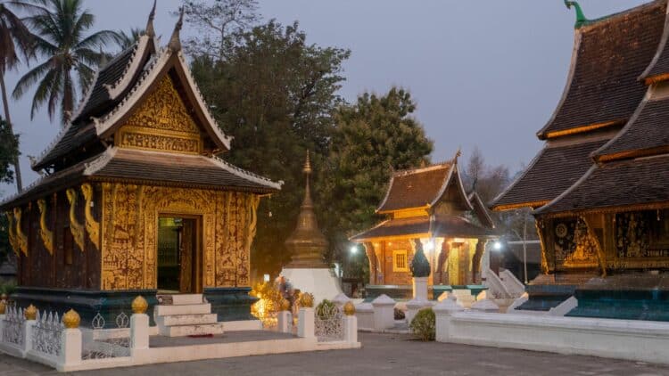 Temples bouddhistes traditionnels illuminés à Luang Prabang avec architecture en bois sculpté au Laos