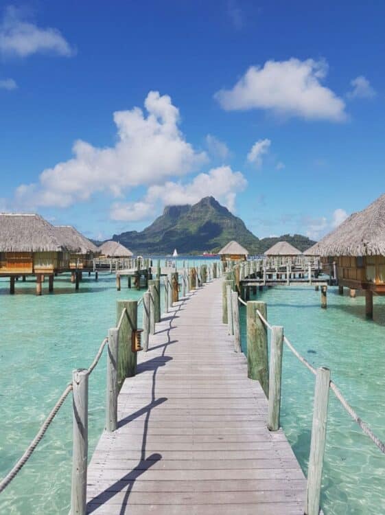 ponton en bois menant à des bungalows sur pilotis dans un lagon turquoise à Bora Bora