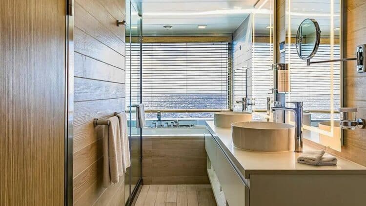 salle de bain moderne dans une cabine de croisière avec double vasque et douche