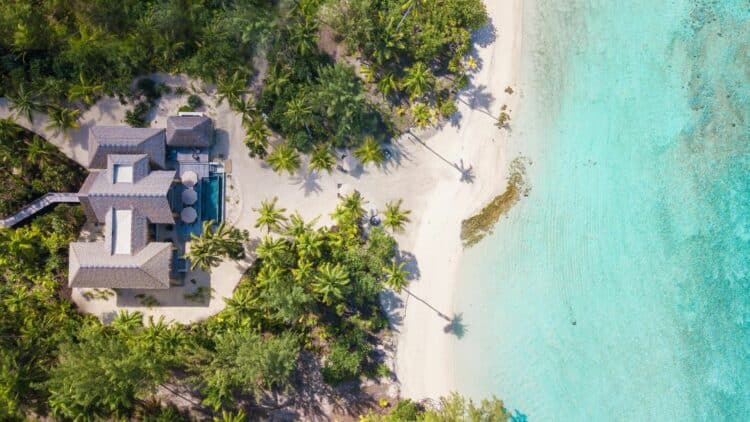 vue aerienne d une villa de luxe sur une ile privee avec plage de sable blanc et lagon turquoise