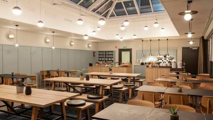 Salle de restaurant d’hôtel en Norvège avec tables en bois et buffet en arrière-plan