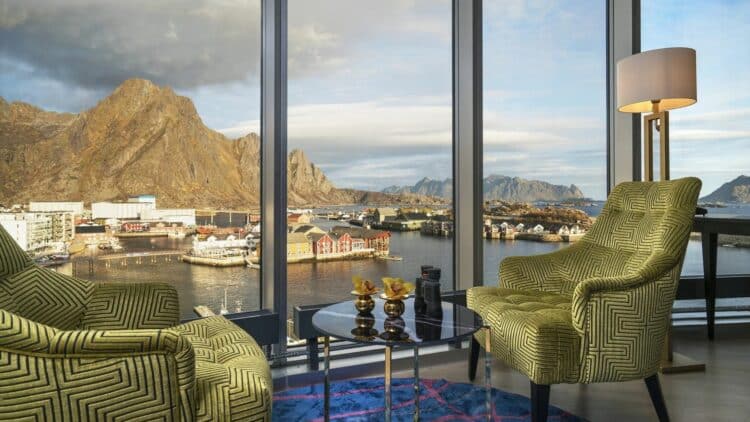 Coin salon avec fauteuils et vue panoramique sur un fjord et des montagnes en Norvège