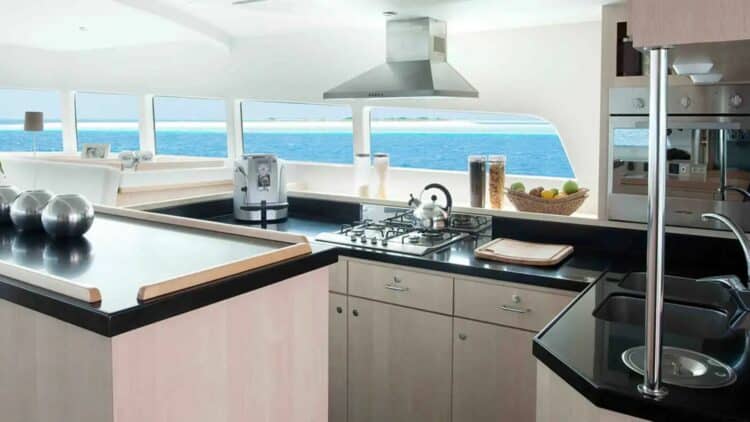 Cuisine équipée moderne à bord d’un catamaran avec vue sur l’océan