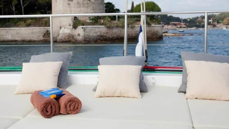 Espace extérieur avec coussins et serviettes sur le pont d’un catamaran en navigation