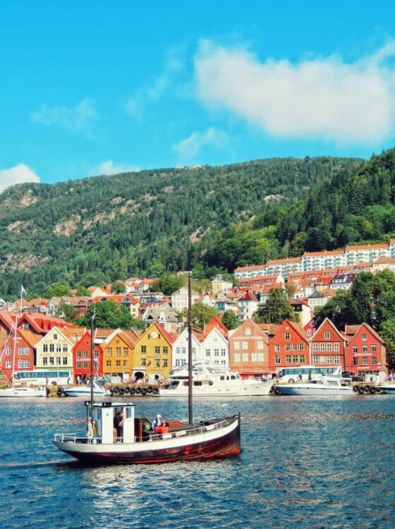 Maisons colorées du port de Bergen avec bateau au premier plan en Norvège