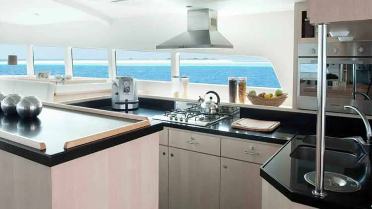 Cuisine équipée de catamaran avec plan de travail moderne et vue sur la mer