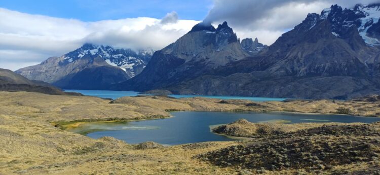 Paysage du parc national Torres del Paine au Chili avec lac turquoise, montagnes rocheuses et sommets enneigés.