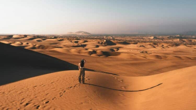 Personne marchant dans des dunes de sable dans un désert au Pérou