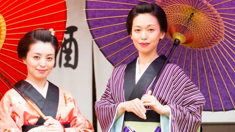 Deux femmes en kimono traditionnel tenant des ombrelles colorées au Japon
