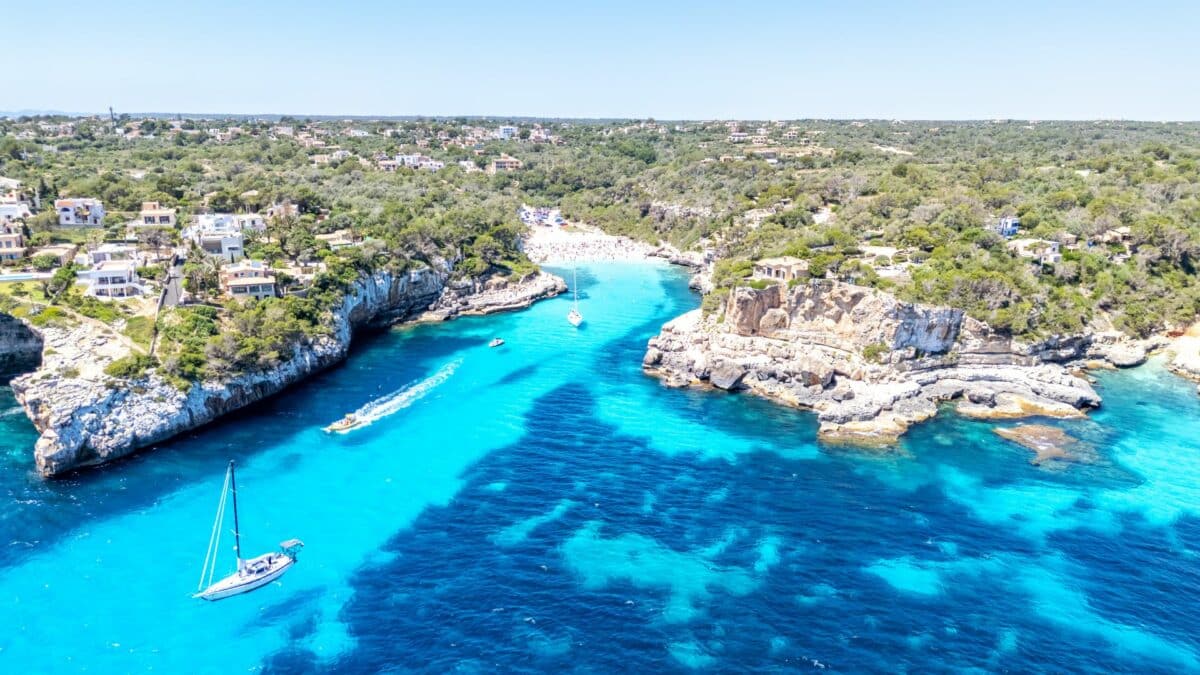 Crique méditerranéenne vue du ciel avec eau turquoise et bateau au mouillage