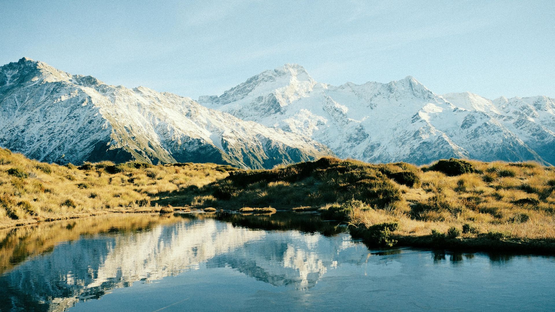 Montagnes enneigées se reflétant dans un lac calme en Nouvelle-Zélande
