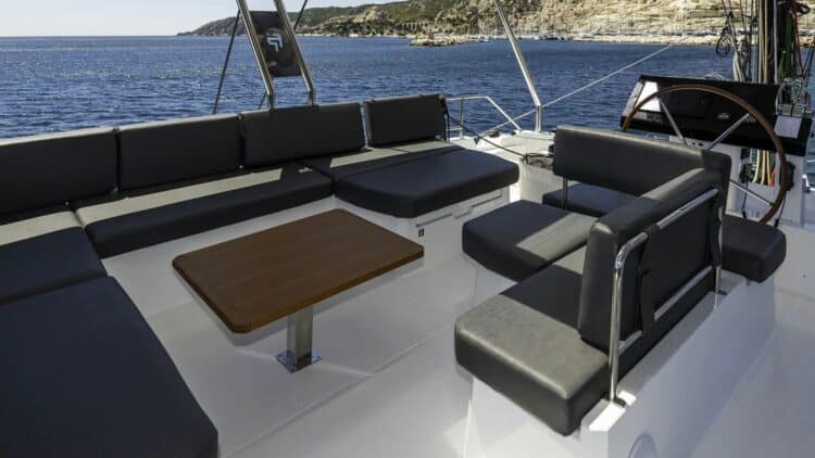 Espace salon extérieur sur le pont d’un catamaran avec vue sur la mer