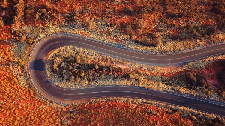 Route sinueuse traversant un paysage désertique rouge en Australie vue aérienne