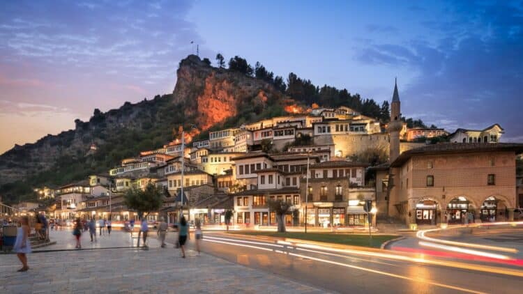 Maisons traditionnelles illuminées dans le centre historique de Berat en Albanie au crépuscule.