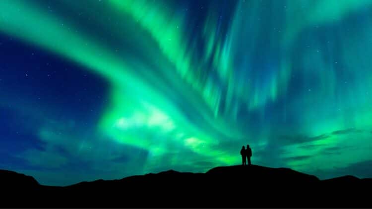 Aurores boréales vertes illuminant le ciel nocturne.