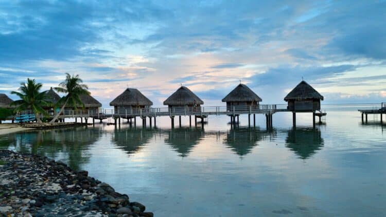 Bungalows sur pilotis au-dessus d’un lagon en Polynésie française.