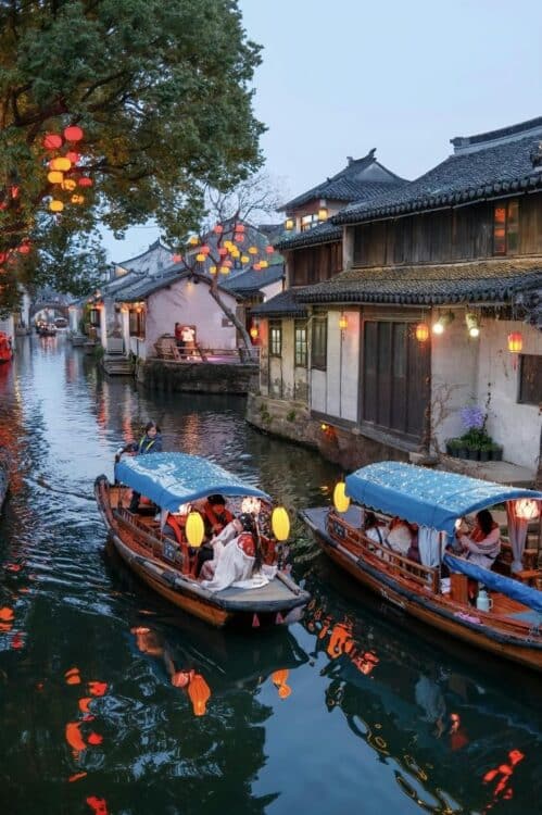 Bateaux sur un canal bordé de maisons traditionnelles à Suzhou, en Chine.