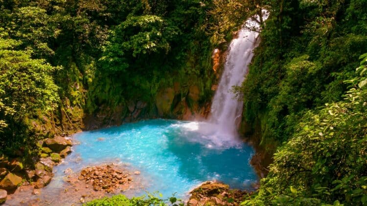 Cascade se jetant dans un bassin d’eau turquoise au cœur de la forêt du Costa Rica.