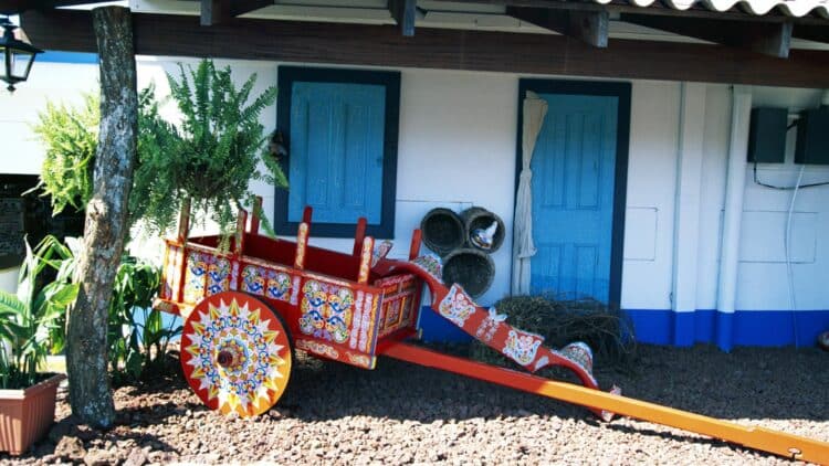 Charrette traditionnelle colorée devant une maison au Costa Rica.