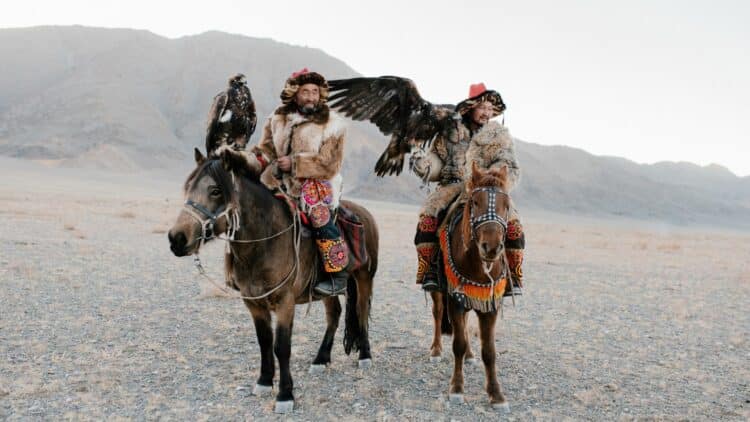 Chasseurs kazakhs à cheval avec leurs aigles dans l’ouest de la Mongolie.