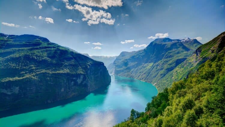 Vue panoramique sur le Geirangerfjord entouré de montagnes verdoyantes, en Norvège.