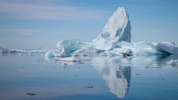 Grand iceberg flottant dans les eaux calmes d'un fjord du Groenland.
