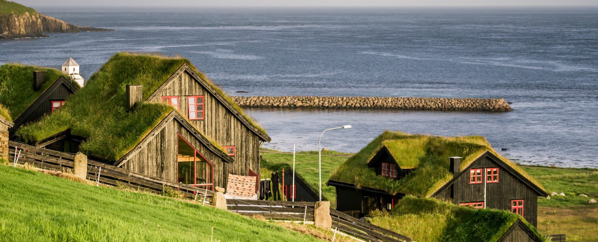 Maisons traditionnelles aux toits végétalisés sur le littoral des îles Féroé.