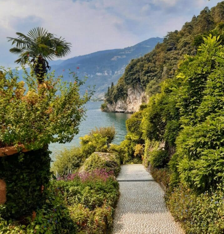 Jardin luxuriant avec vue sur le lac de Côme entouré de montagnes en Italie.